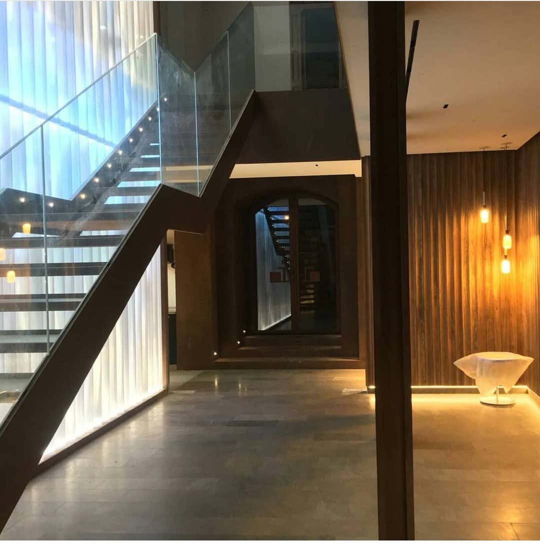 Escalera de hotel con zancas metálicas y barandilla de vidrio