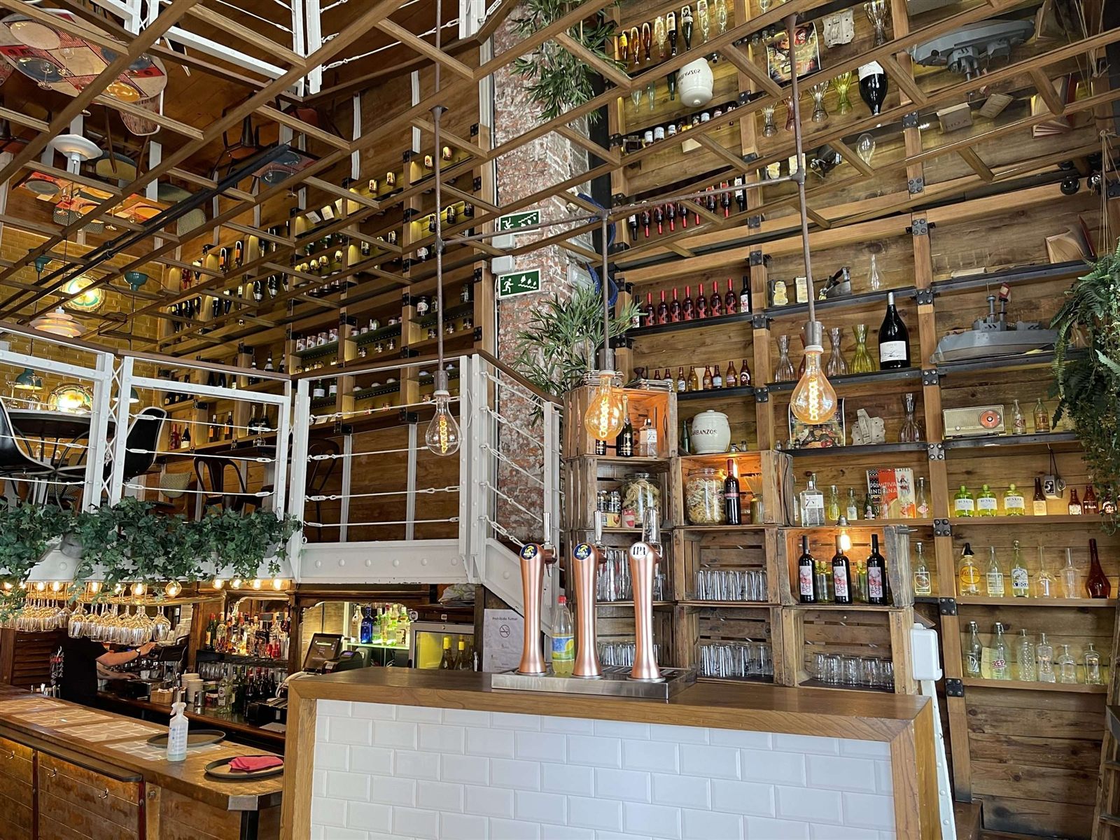 Interior de restaurante con estanterías y estructura metálica combinada con madera