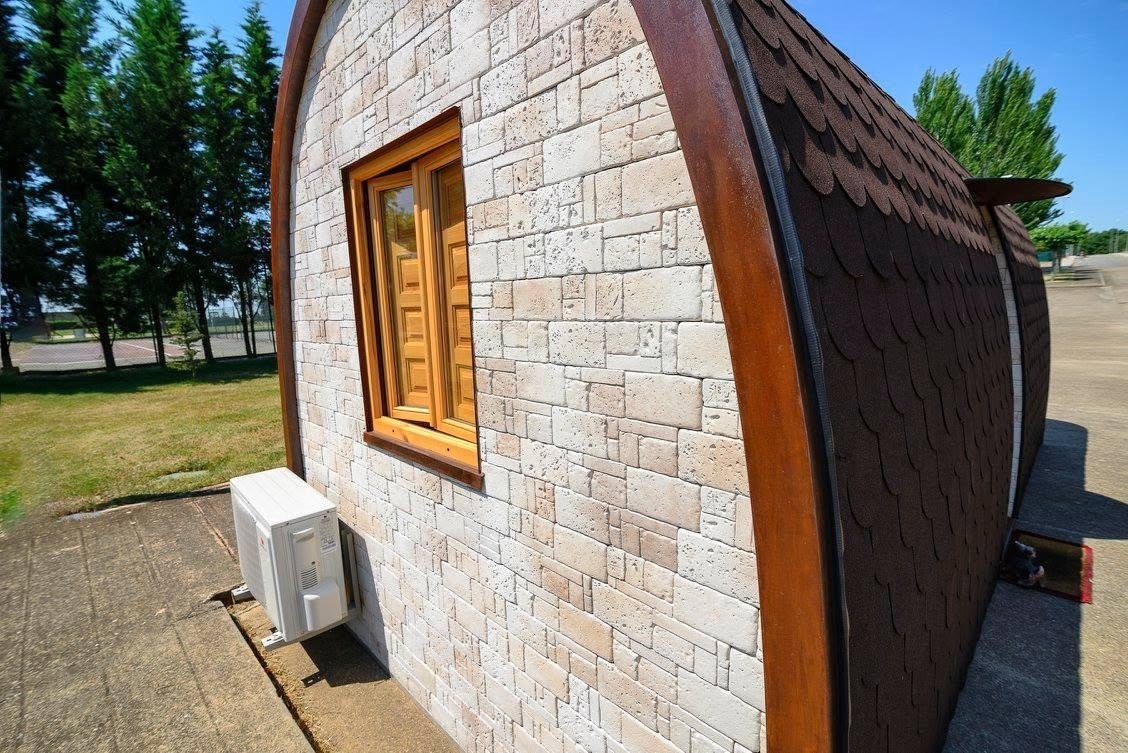 Fachada de Maxicozy con acabado de piedra y arco frontal