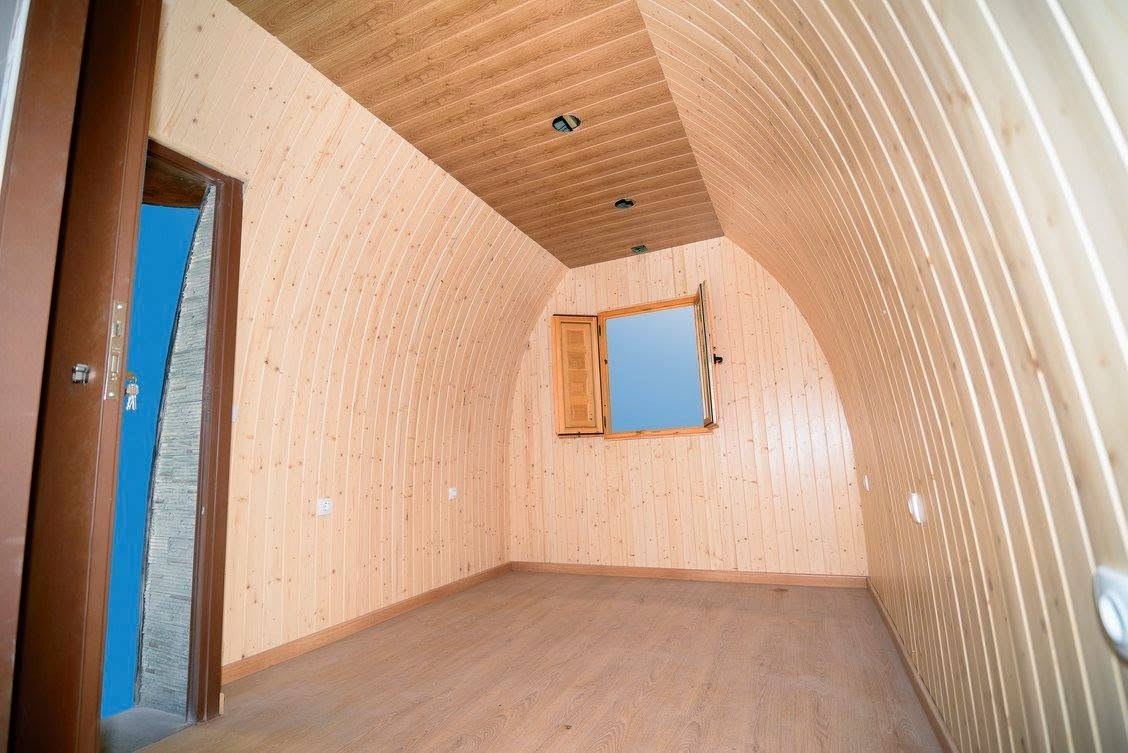 Interior de bungalow Maxicozy con panelado de madera natural y forma barrel-vaulted